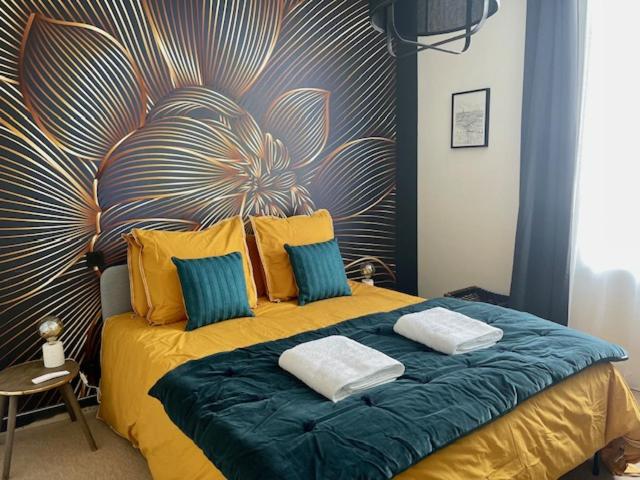 a bed with two pillows on it in a room at MAISON LE BEAULIEU in Vichy