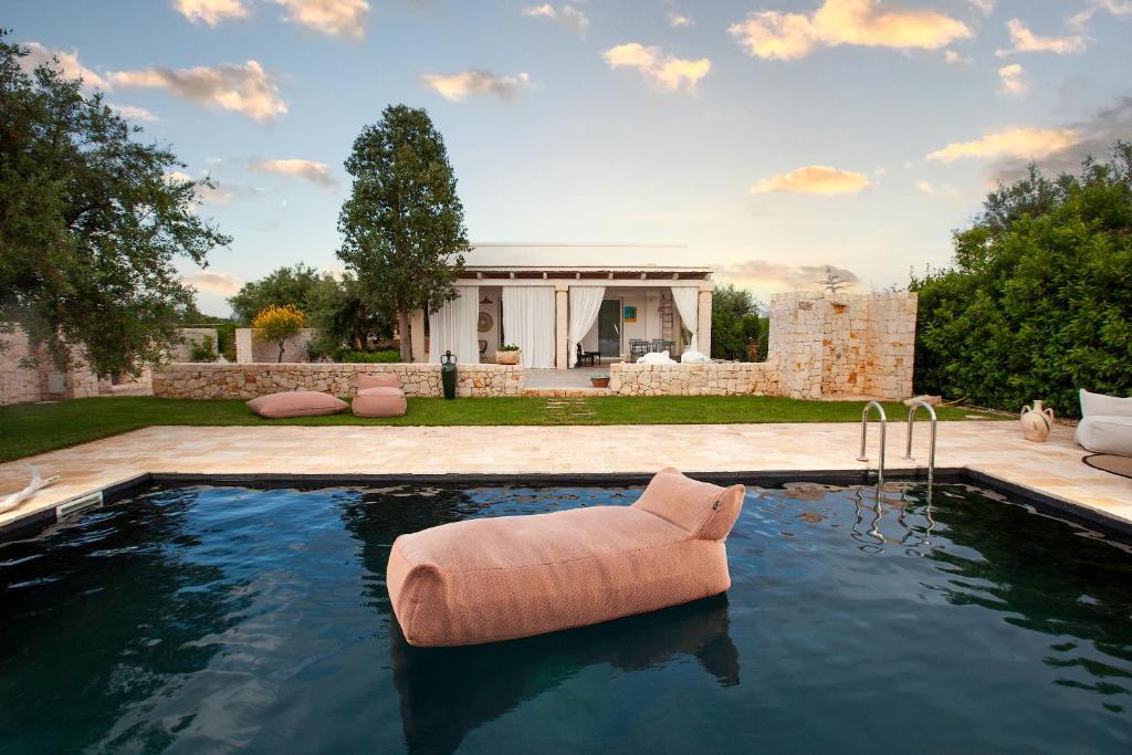 una piscina con una silla en medio de un patio en Casa mia in Puglia, en Conversano