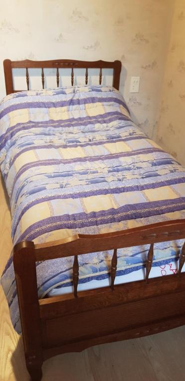 ein Bett mit einer blau-weißen Decke drauf in der Unterkunft Lieu dit kerleo in Melgven