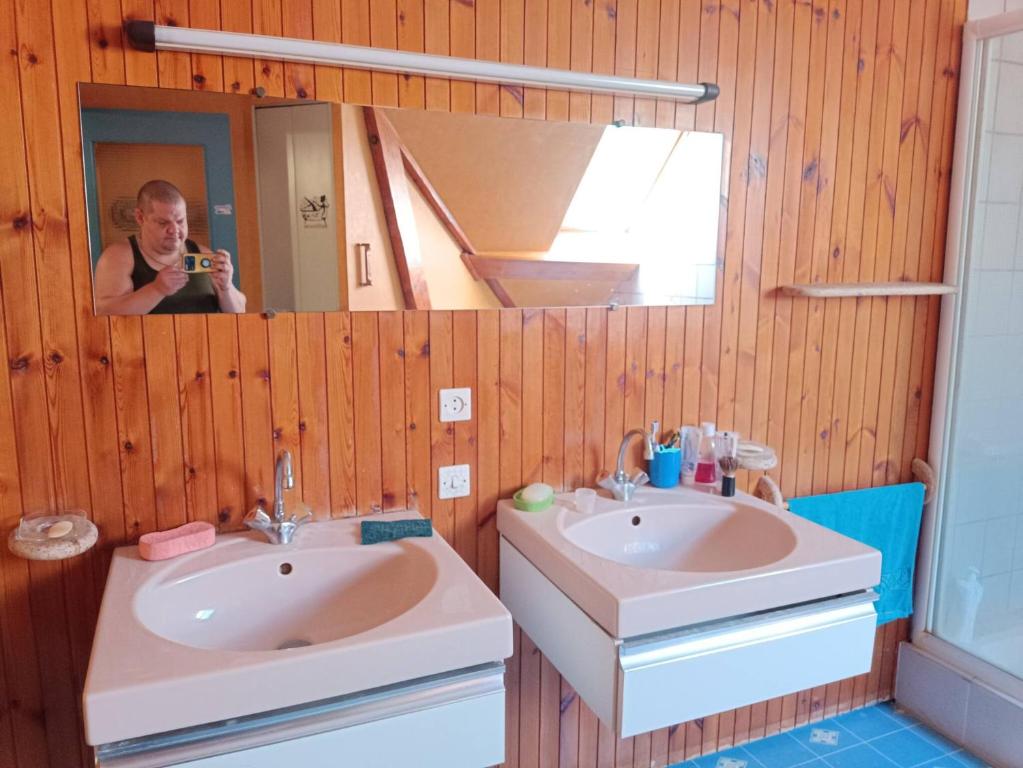 uma mulher tirando uma foto de uma casa de banho com dois lavatórios em Room in BB - Lit 2 Personnes Avec Un Grand Bureau em Fruges