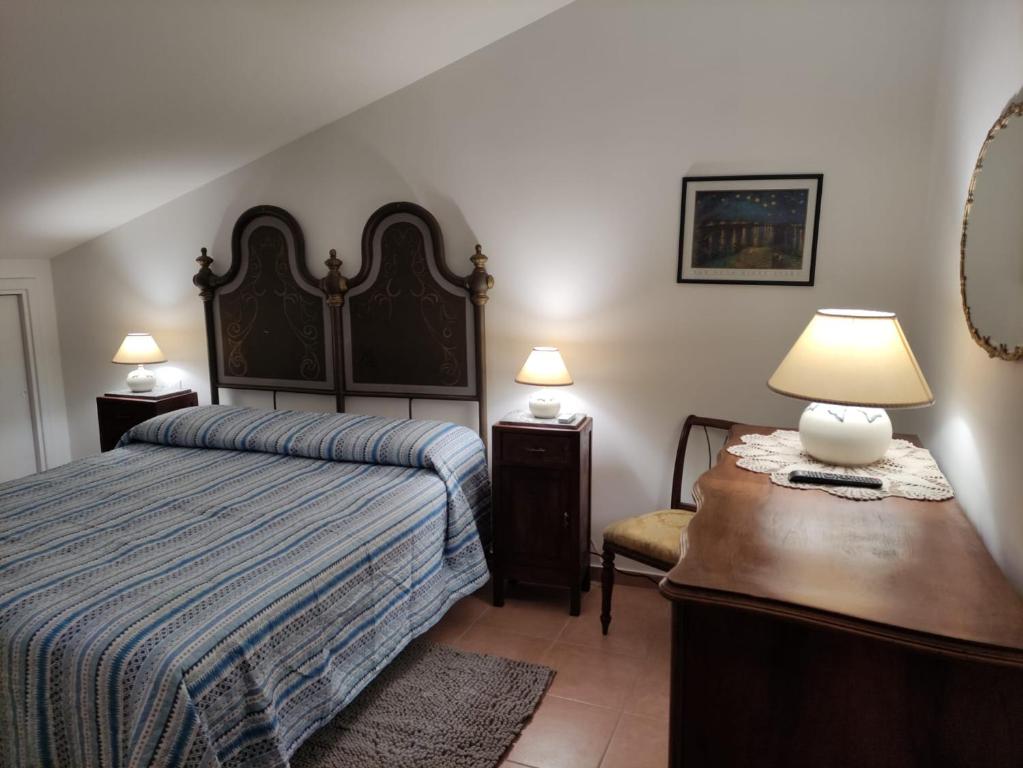 1 dormitorio con 1 cama y 1 mesa con lámpara en casa vacanze degli archi en Otricoli