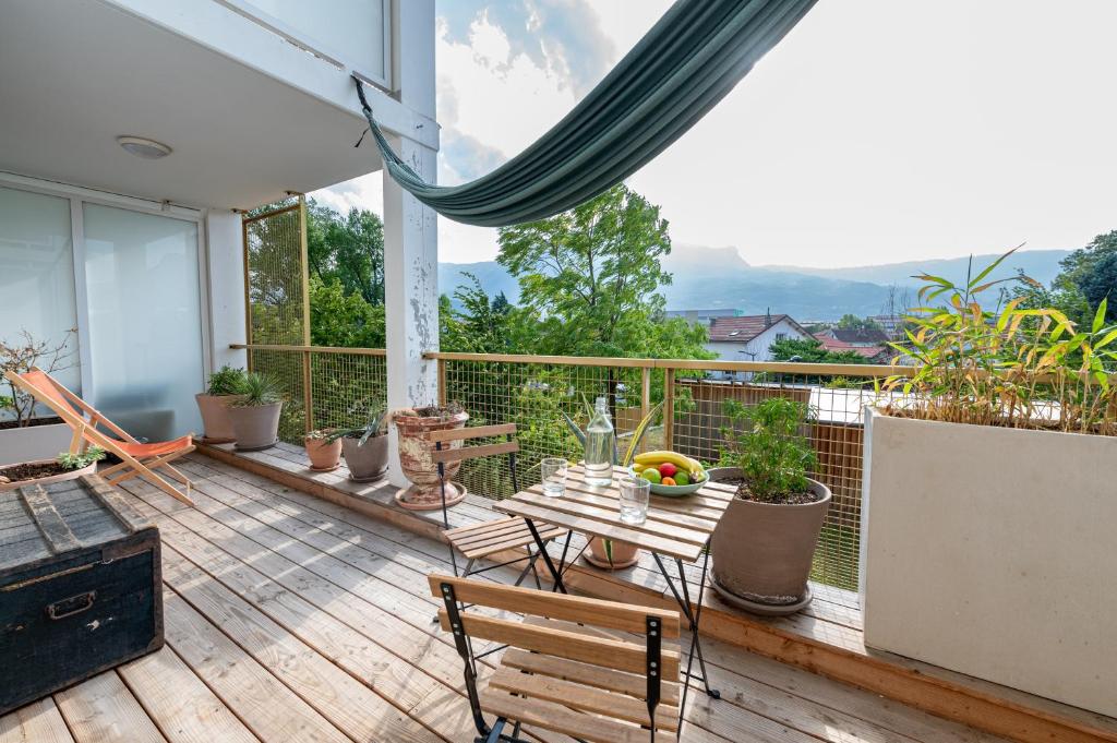 un patio avec une table et des chaises sur un balcon dans l'établissement Calme et verdure: vue montagne - terrasse - wifi, à Grenoble