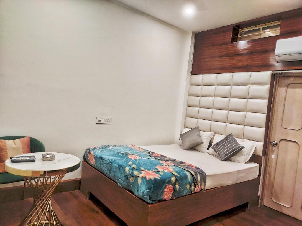 a small bedroom with a bed and a table at Hotel Florence in Siliguri
