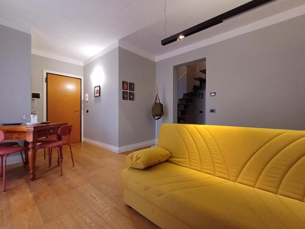 een gele bank in een woonkamer met een tafel bij aldueci in Ravenna