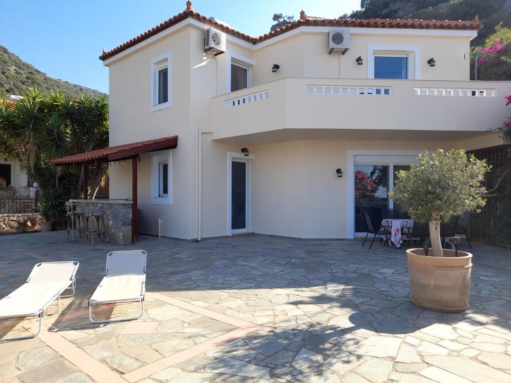 ein weißes Haus mit einer Terrasse davor in der Unterkunft Villa Calli in Malia