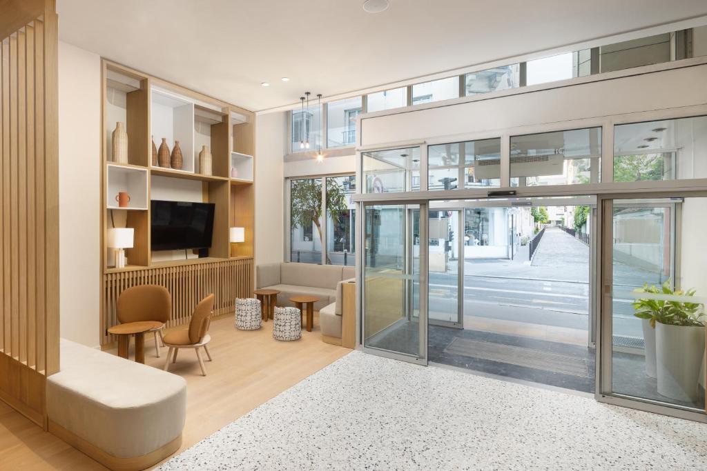 a living room with a sliding glass door at Residence Inn by Marriott Paris Didot Montparnasse in Paris