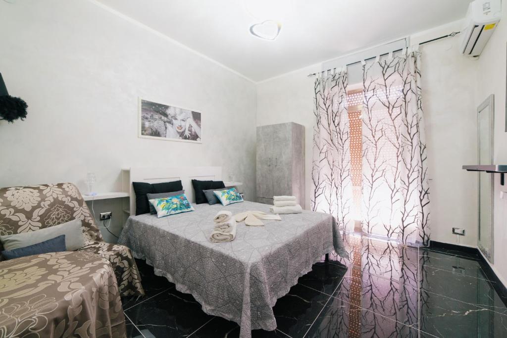 ナポリにあるLa dimora delle ziteのベッド1台、椅子、窓が備わる客室です。