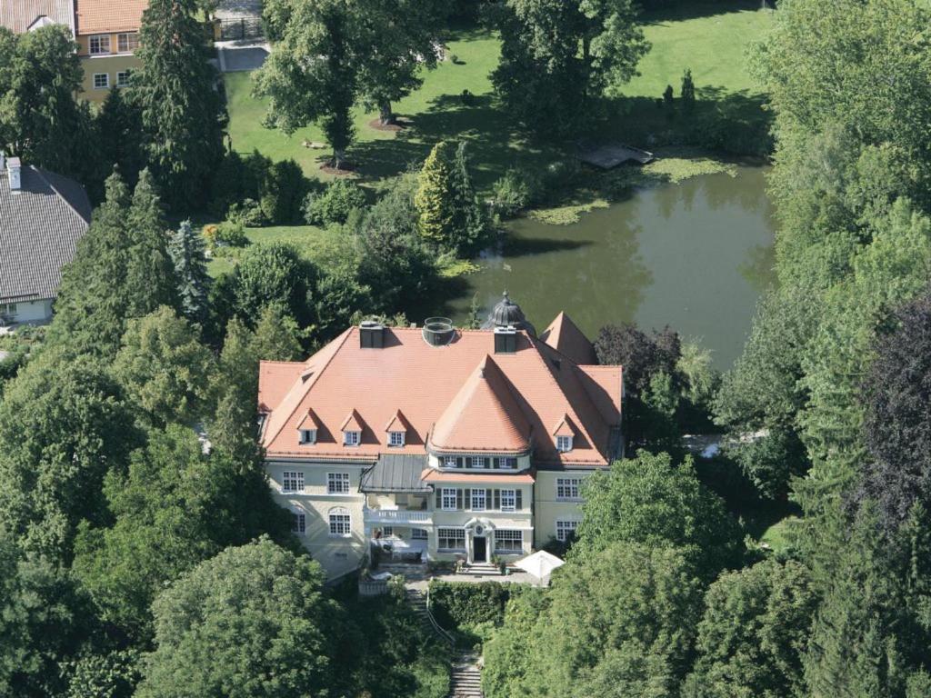 an aerial view of a large house with a lake at Schloss Mörlbach in Mörlbach