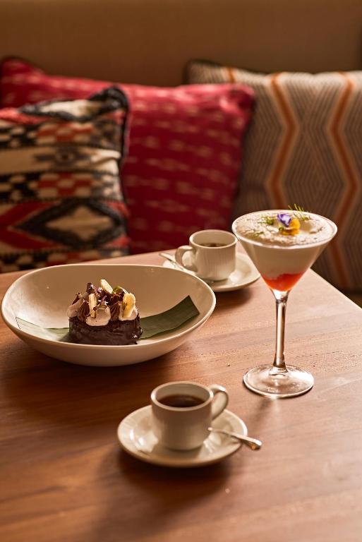 a table with two plates of food and a drink at TRS Ibiza Hotel - Adults Only in San Antonio