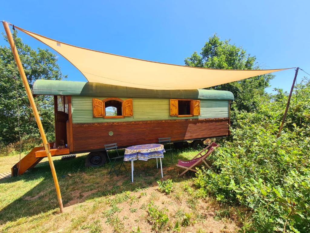 an old train car with a tent over it at La Roulotte du Coustal, Cajarc, Lot in Cajarc