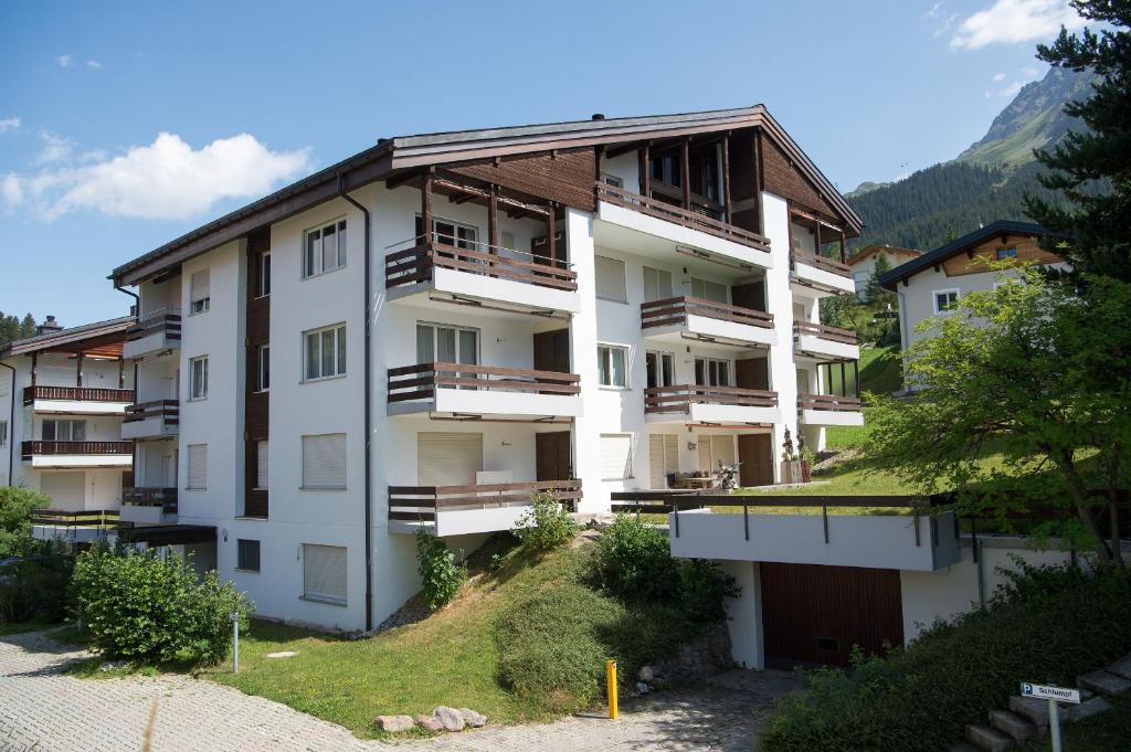 ein Apartmenthaus mit Balkon auf einem Hügel in der Unterkunft Central flat for 6 persons Pianura Crapera Lenzerheide in Lenzerheide