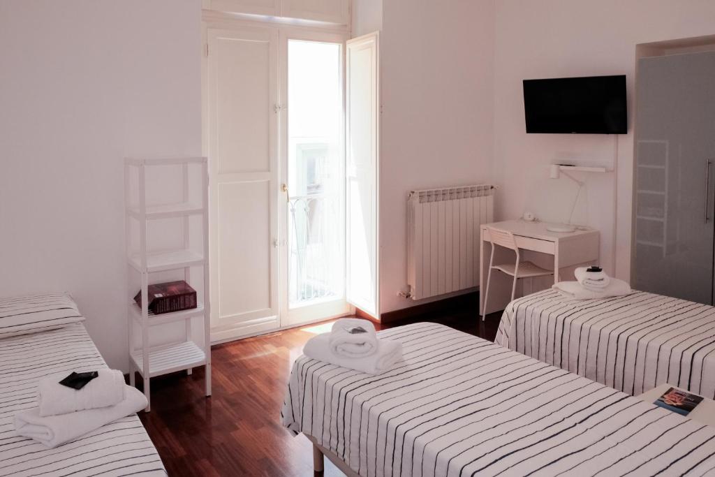 a hotel room with two beds and a television at Casa Maria Al Campo in Salerno