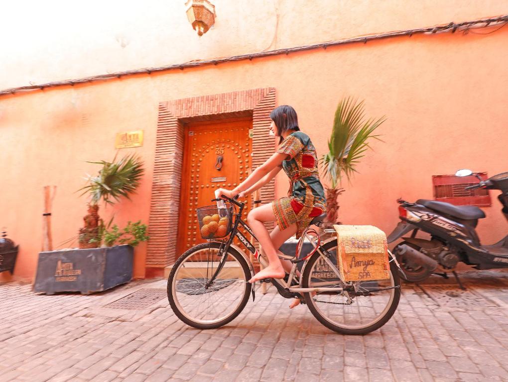 une femme en robe à vélo dans l'établissement Riad Amya & Spa, à Marrakech