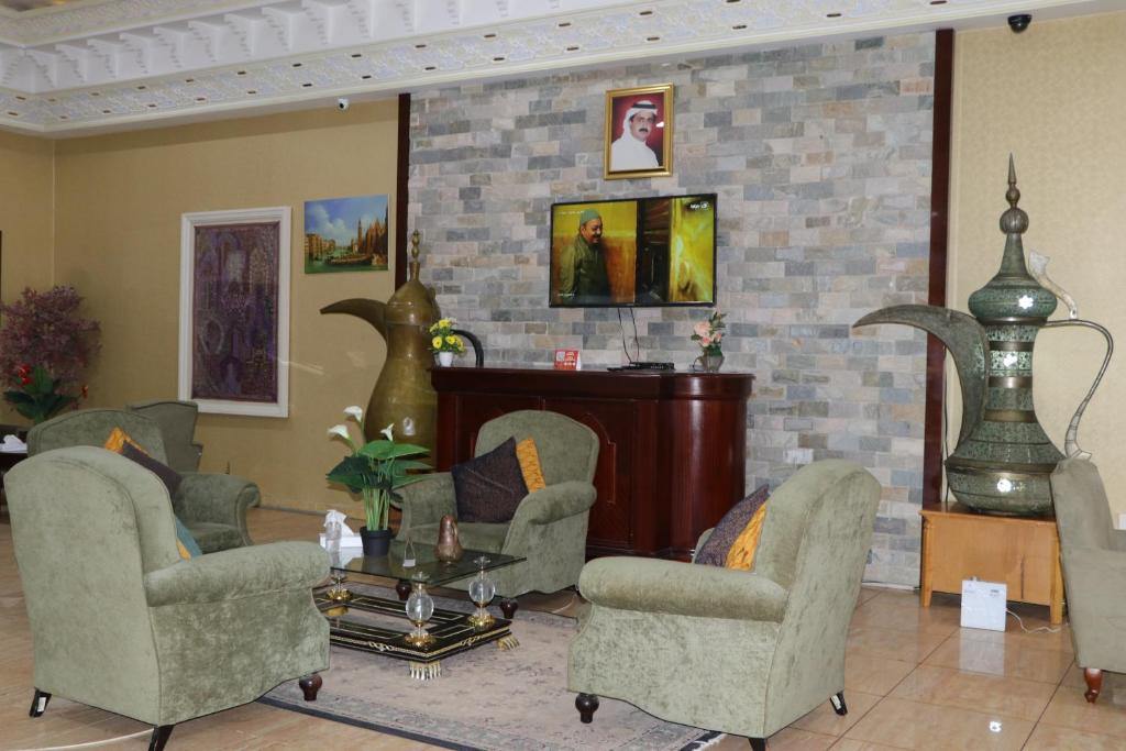 a living room with two chairs and a table at Sharjah International Airport Hotel in Sharjah