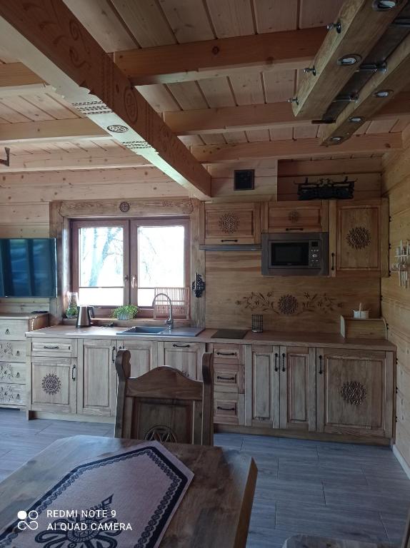 una cucina con armadi in legno e un tavolo in una cabina di Domki ,,Goramiba'' a Jurgów