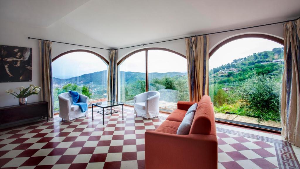 ein Wohnzimmer mit einem karierten Boden und großen Fenstern in der Unterkunft Natursteinvilla mit Meerblick , 2km über dem Meer-Cilentissimo in Santa Maria di Castellabate