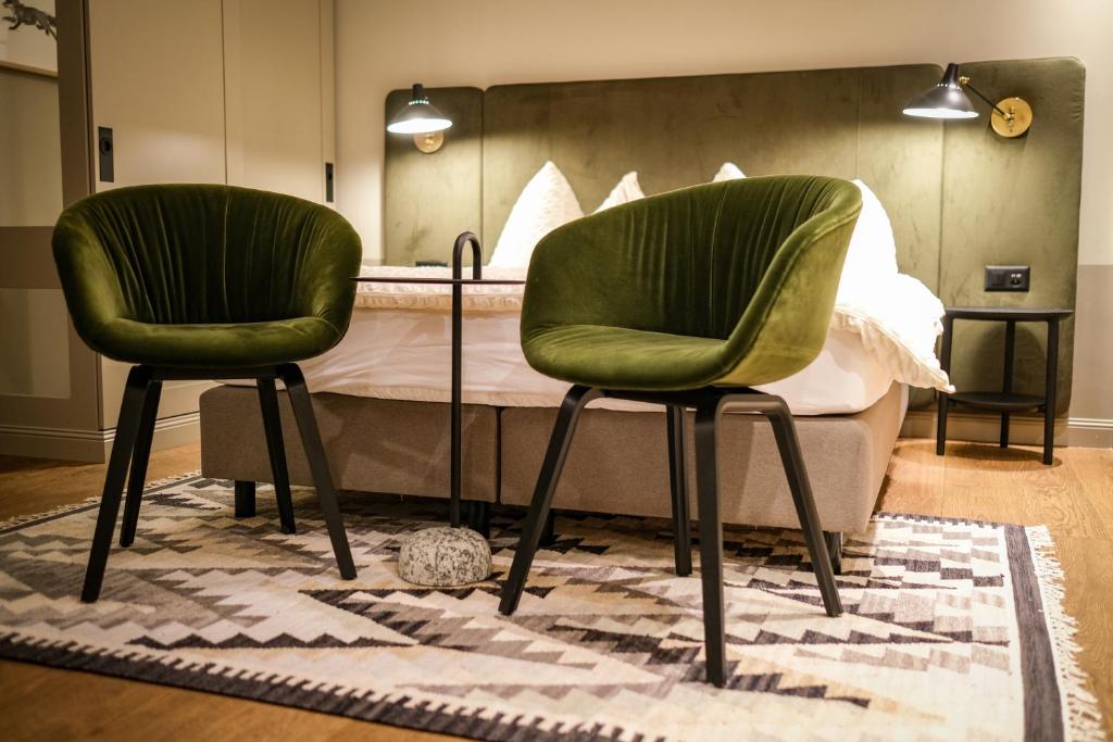 zwei grüne Stühle neben einem Bett in der Unterkunft Mountain Paradise in Zermatt
