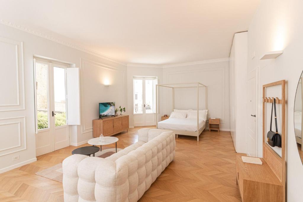 un soggiorno bianco con divano e letto di Suite n.4 a Conversano