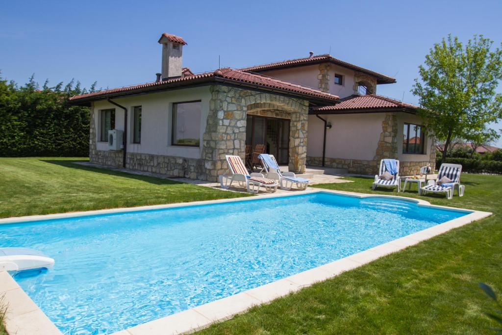 a swimming pool in front of a house at Villa Golf and Relax in Balchik