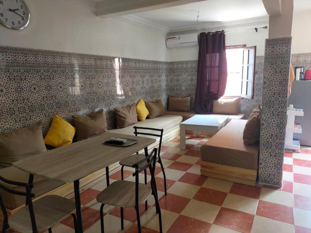 een woonkamer met een bank en een tafel bij Appartement Relax Marrakech, شقة عائلية بمراكش متوفرة على غرفتين in Marrakesh