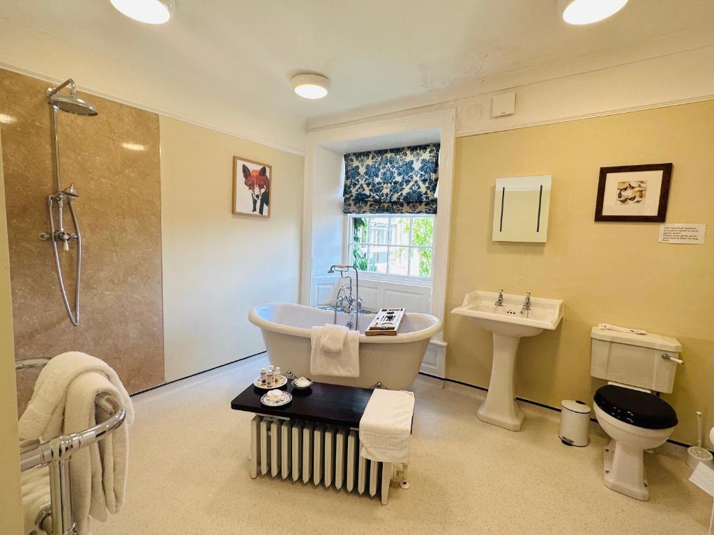 a bathroom with a tub and a toilet and a sink at Porters Coffee Shop and B&B in Helmsley