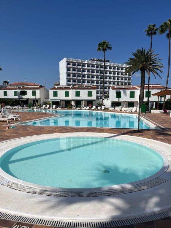 a large swimming pool in front of a hotel at Bungalow Carmen in San Bartolomé