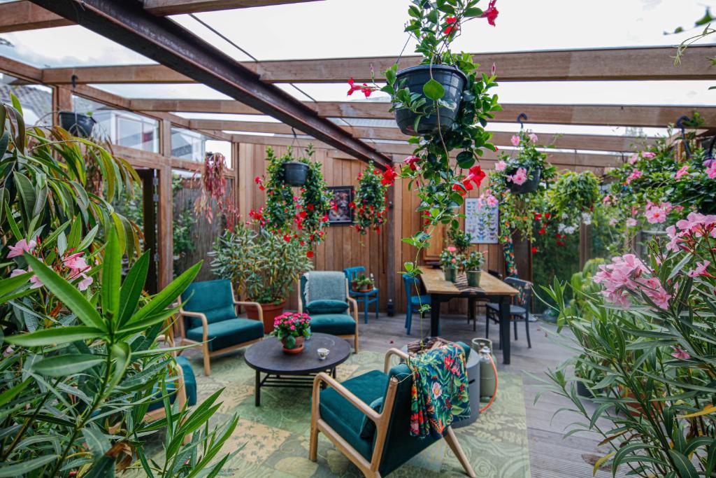 un patio con sillas, mesas y plantas en The Explorer's Hostel 