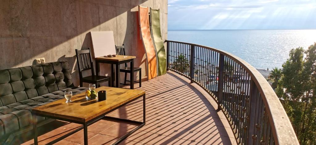 een balkon met een tafel en uitzicht op de oceaan bij Batumi-Gonio First line Apartment in Gonio