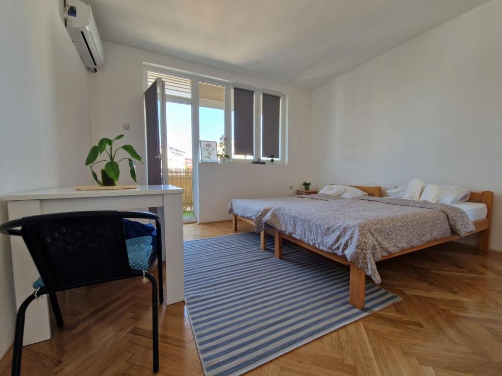 a bedroom with a bed and a table and a chair at Apartman REA 1 in Pirot