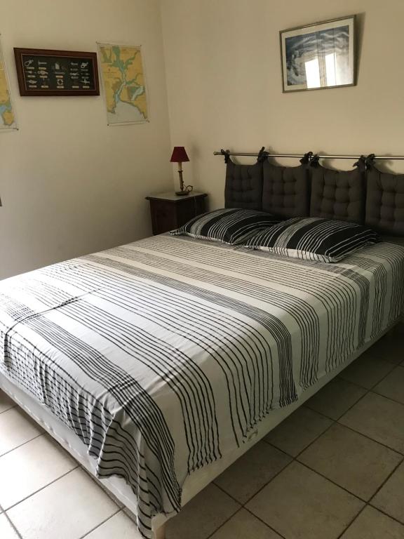 1 dormitorio con 1 cama grande con manta a rayas en Chambre Haute mer, en Montpellier