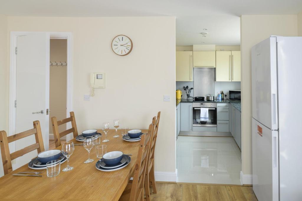 a dining room with a table with chairs and a refrigerator at The Tower Bridge Cosy Flat in London