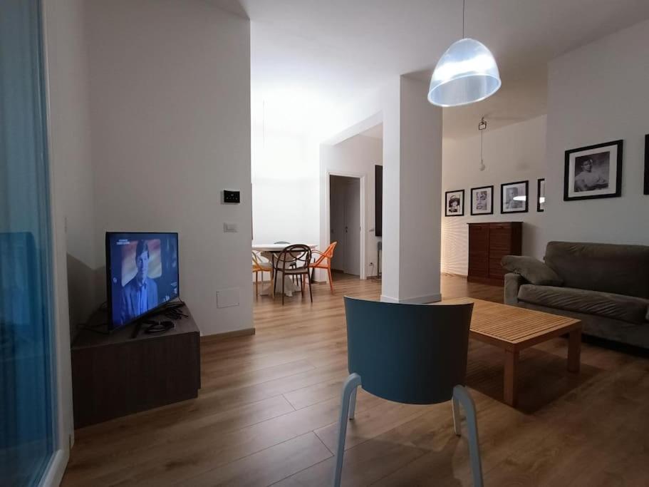 un soggiorno con divano, tavolo e TV di Rifugio a Metanopoli con cucina attrezzata a San Donato Milanese