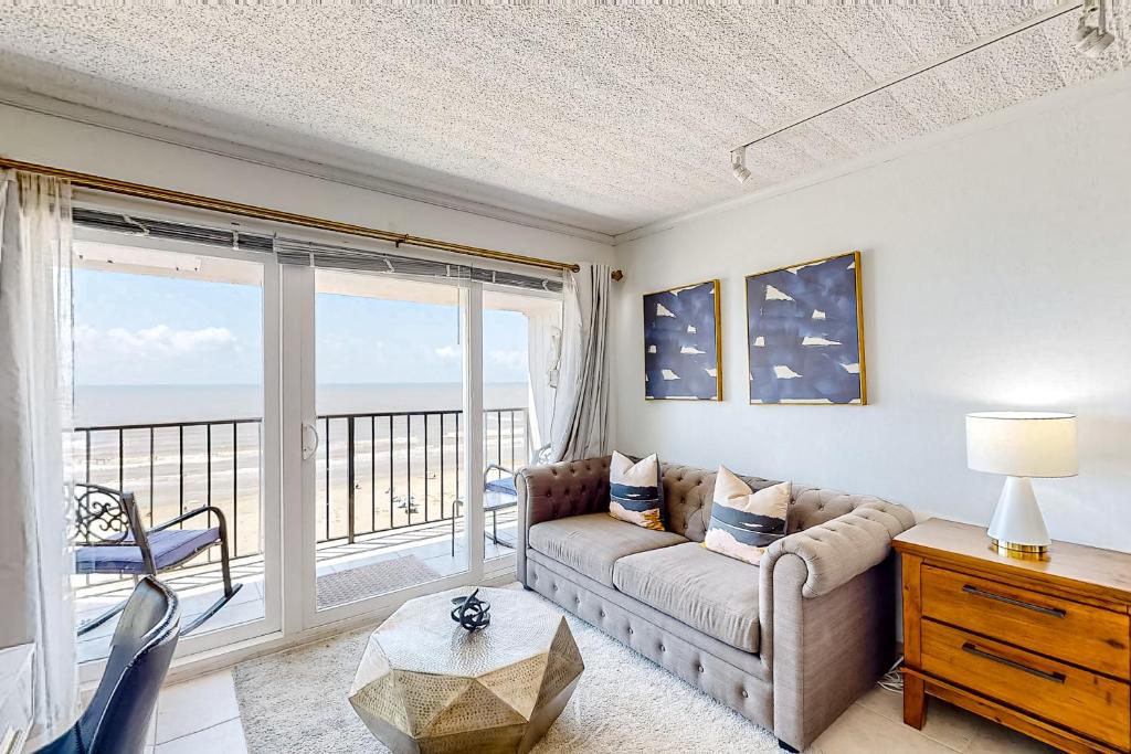 a living room with a couch and a view of the ocean at Ocean Escape By the Sea in Galveston