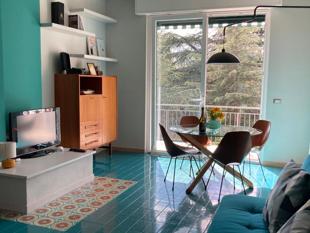 ein Wohnzimmer mit einem TV und einem Tisch mit Stühlen in der Unterkunft The Silky Way in Como
