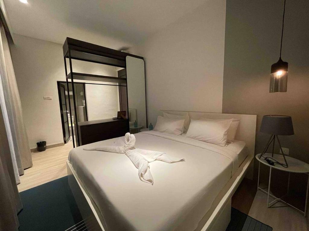 a bedroom with a white bed with a towel on it at Monde Residence H 15 Batam Centre in Sengkuang