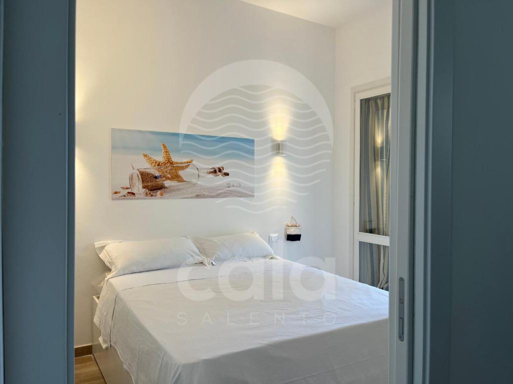 um quarto com uma cama com um quadro na parede em Room 401 - Piano Primo em Porto Cesareo