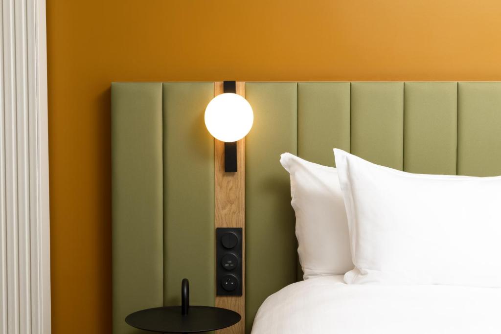 a bedroom with a bed and a lamp on the wall at Residence Inn by Marriott Paris Didot Montparnasse in Paris