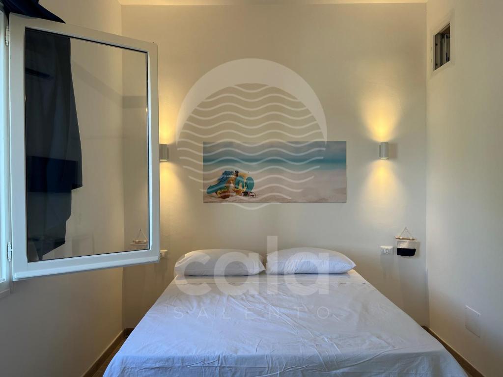 um pequeno quarto com uma cama e uma janela em Room 404 - Piano Primo em Porto Cesareo