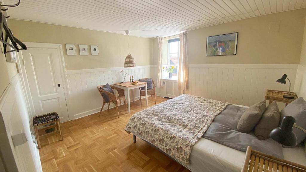 1 dormitorio con cama, mesa y ventana en Holsteinshus B&B, en Odder