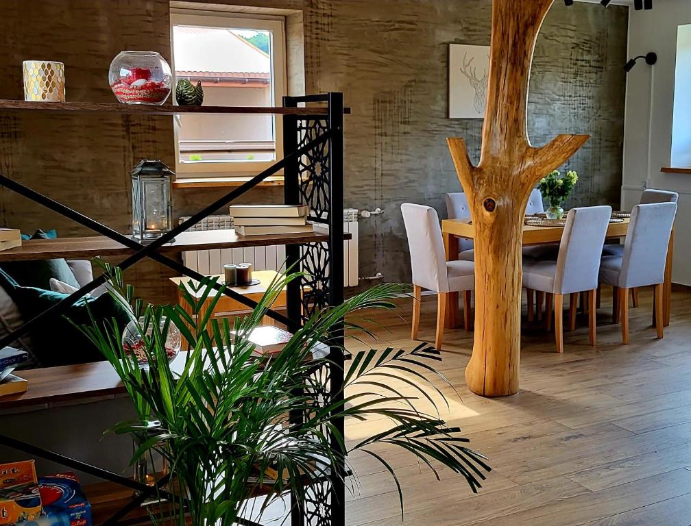 una sala da pranzo con tavolo e albero di Apartament pod Grodziskiem 