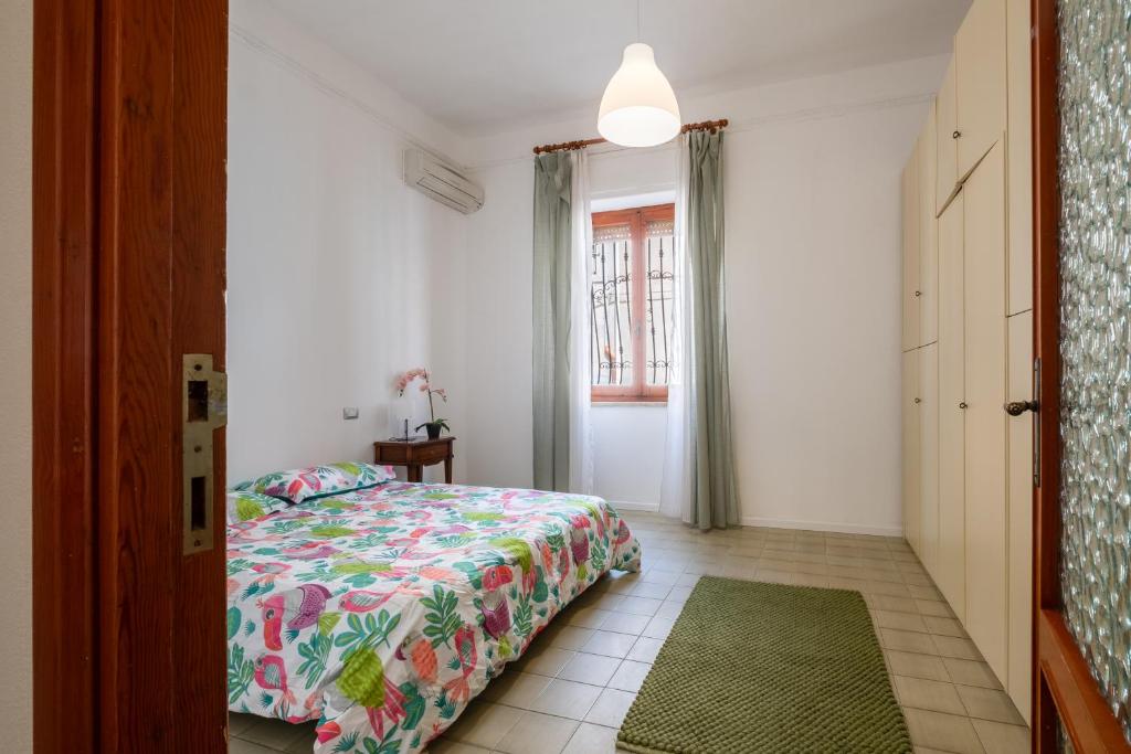 ein Schlafzimmer mit einem Bett und einem grünen Teppich in der Unterkunft Maison Adriana con giardino - 10 minuti dal Poetto e dal Parco Molentargius in Quartu SantʼElena