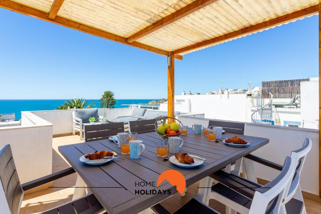 uma mesa com comida em cima de uma varanda em #086 Fish House by Home Holidays em Albufeira