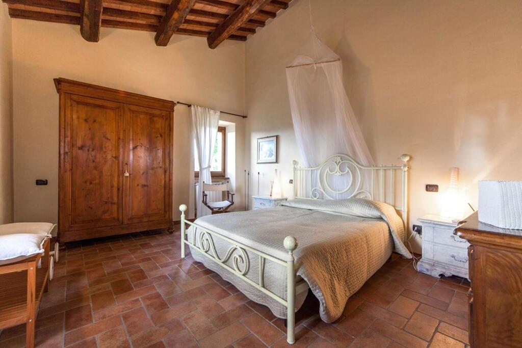 1 dormitorio con 1 cama y armario de madera en Villa San Giglio - Homelike Villas, en Foligno