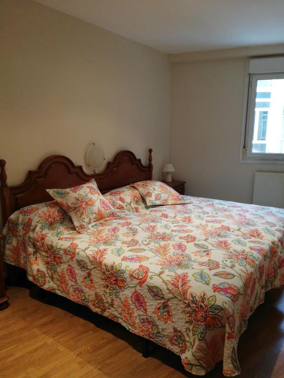 1 dormitorio con 1 cama con edredón de flores en Casa Güelito, en Candás