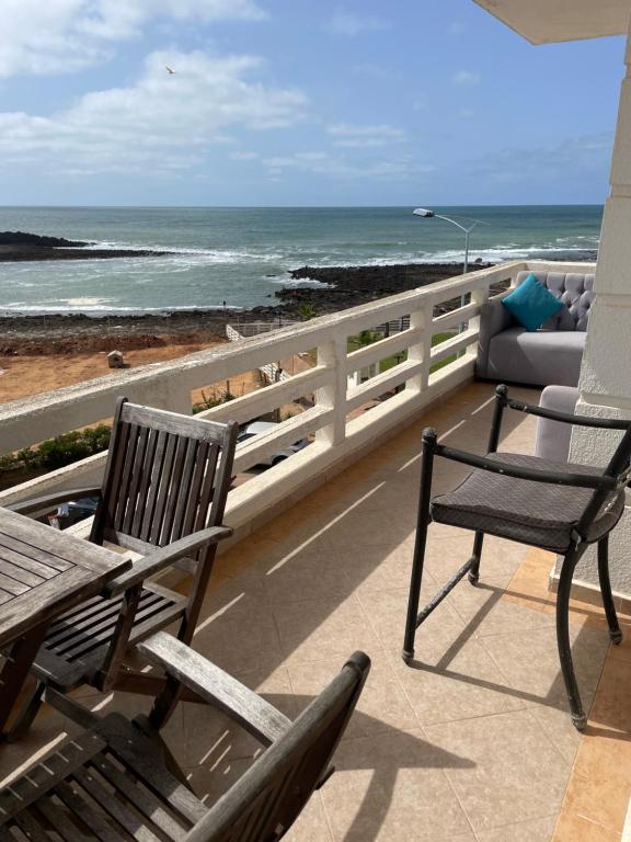 2 stoelen en een tafel op een balkon met uitzicht op de oceaan bij marina beach mohammedia in Mohammedia