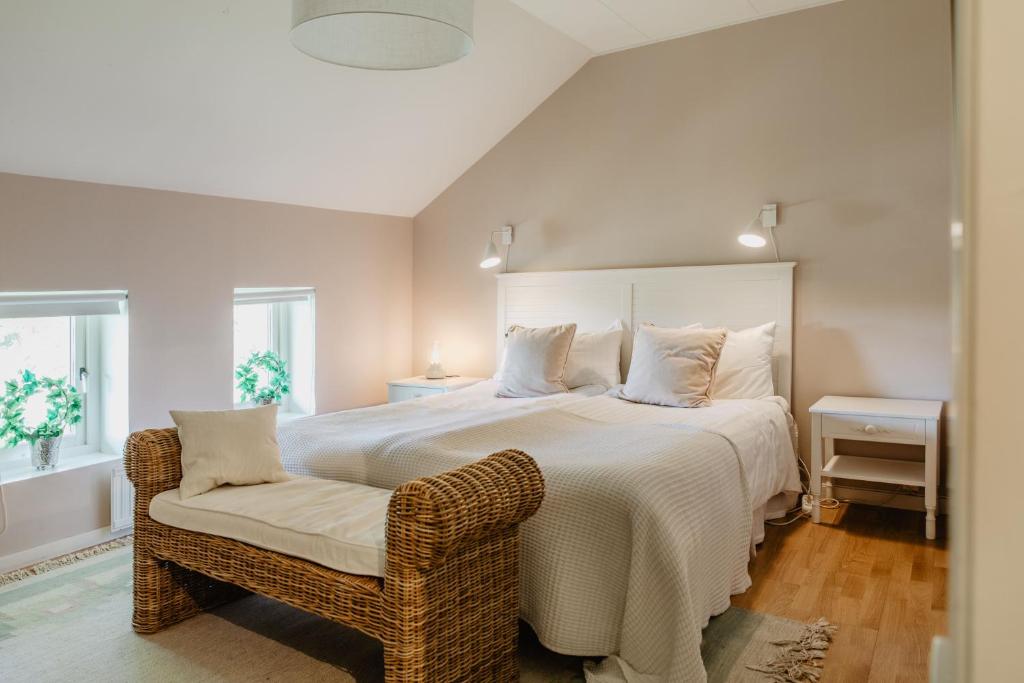 a bedroom with a large white bed and a chair at Slottsparken Motel in Huskvarna