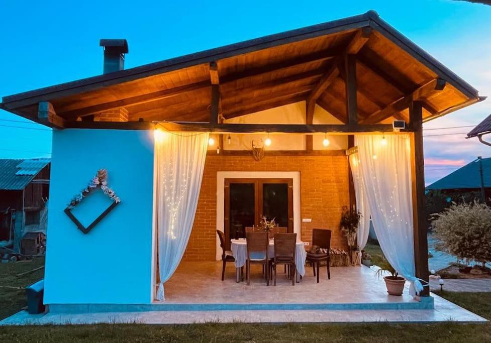 einen Pavillon mit einem Tisch und Stühlen auf einer Terrasse in der Unterkunft La Casetta - O întreagă căsuță ca în povești in Baia Sprie