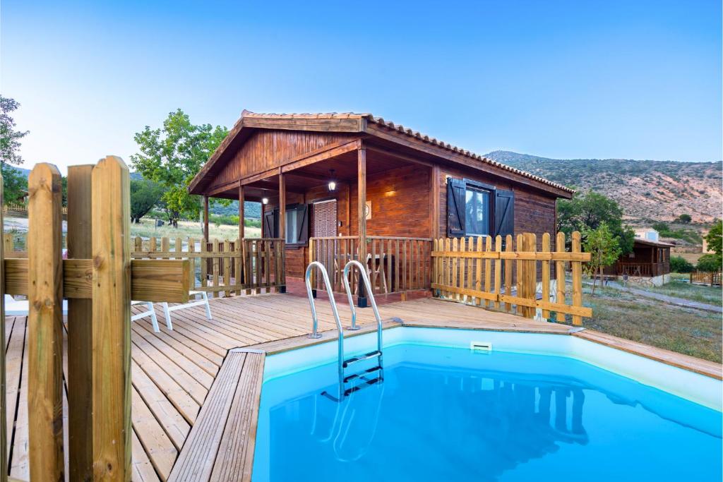 Cabaña de madera con piscina y terraza de madera en Aldea Los Odres - Cabañas de Madera de 1ª con Piscina Privada y BBQ en la puerta, en Moratalla