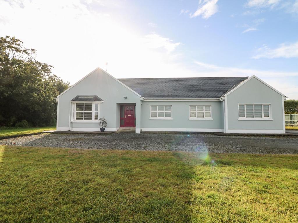 a white house with a red door at Hook Head Hideaway 