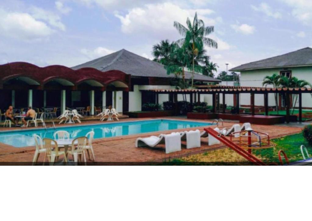 un resort con piscina attrezzata con tavoli e sedie di Hotel Vila Rica Belém a Belém